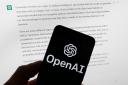 FILE – The OpenAI logo is seen on a mobile phone in front of a computer screen displaying output from ChatGPT, March 21, 2023, in Boston. OpenAI has introduced a new artificial intelligence model. It says it works faster than previous versions and can