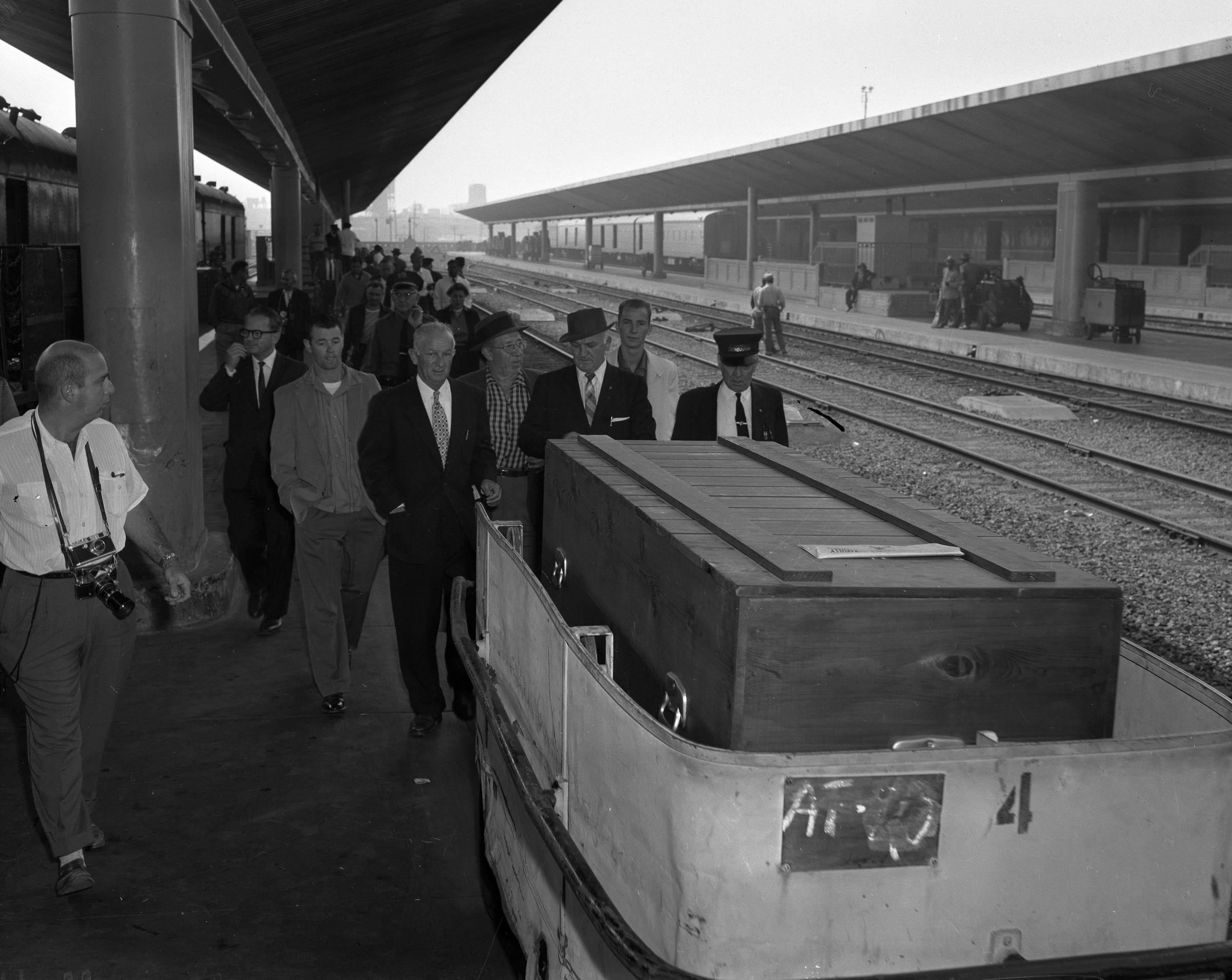 Errol Flynns coffin on Los Angeles Union Station train platform in 1959. In dark suit and hat behind the coffin is Buster Wiles, Flynns double and friend. Photo: Los Angeles Times archive