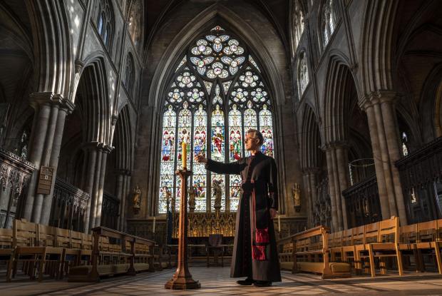 St Albans & Harpenden Review: Very Reverend John Dobson Dean of Ripon lights a candle to mark the second anniversary of the first national coronavirus lockdown at Ripon Cathedral, North Yorkshire, ahead of the National Day of Reflection on Wednesday (PA)