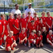 Anton and Rio Ferdinand with a team of young footballers.